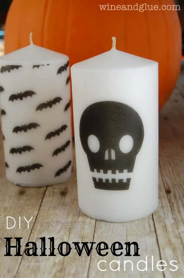two white candles with halloween graphics on them
