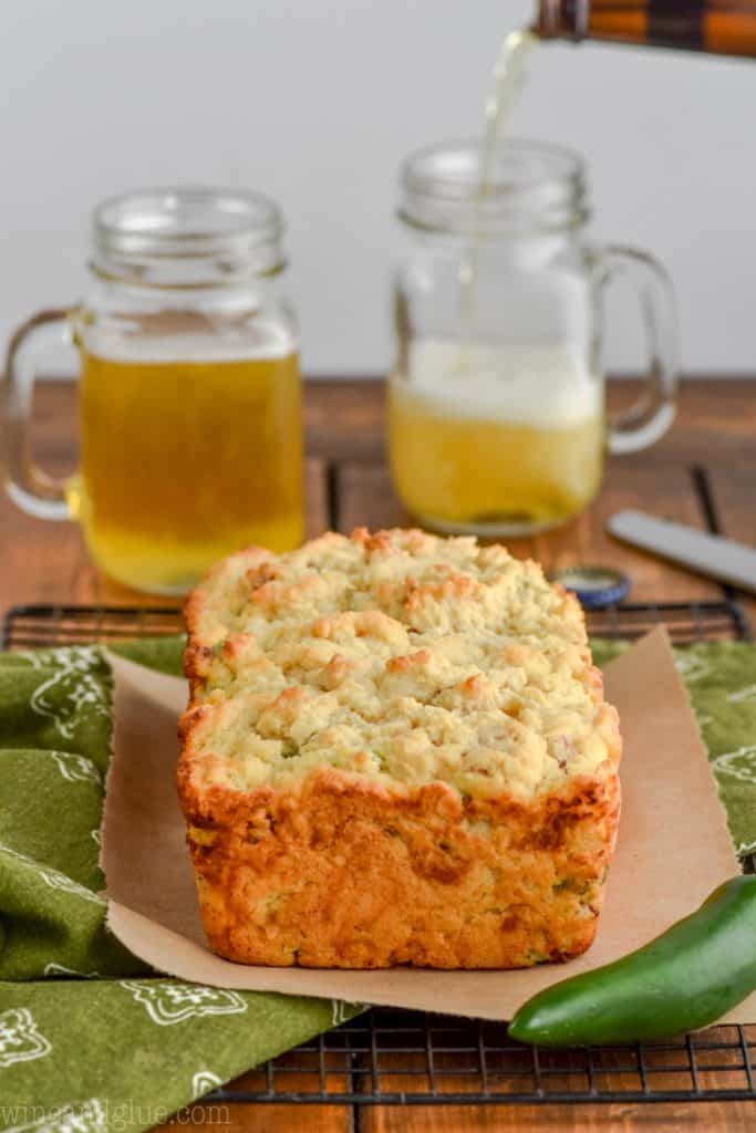 front on view of a loaf of jalapeno popper beer bread with beer mugs in the background