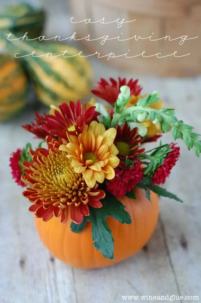 small pumpkin with a flower arrangement coming out of it, says "easy thanksgiving centerpiece"