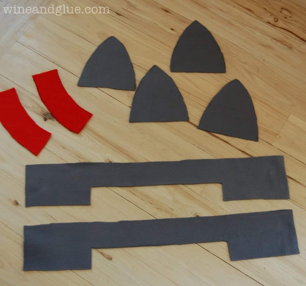 pieces of fleece cut out to make a knight hat on a floor