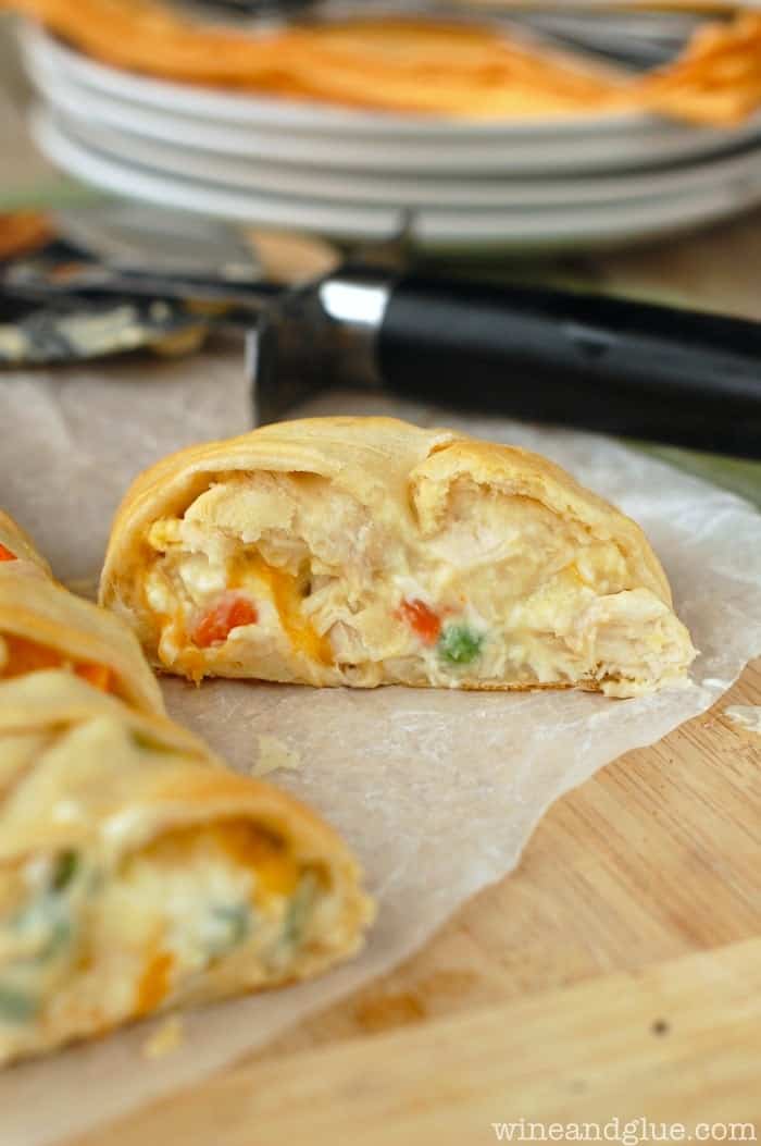 close up of the cut off end of a chicken pot pie crescent braid with its oozing center and pastry crust