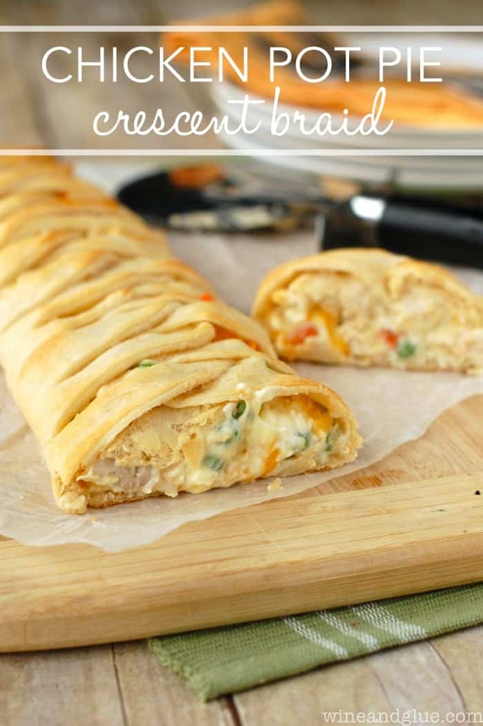 a close up of a crescent braid filled with chicken pot pie filling, cut open on a cutting board