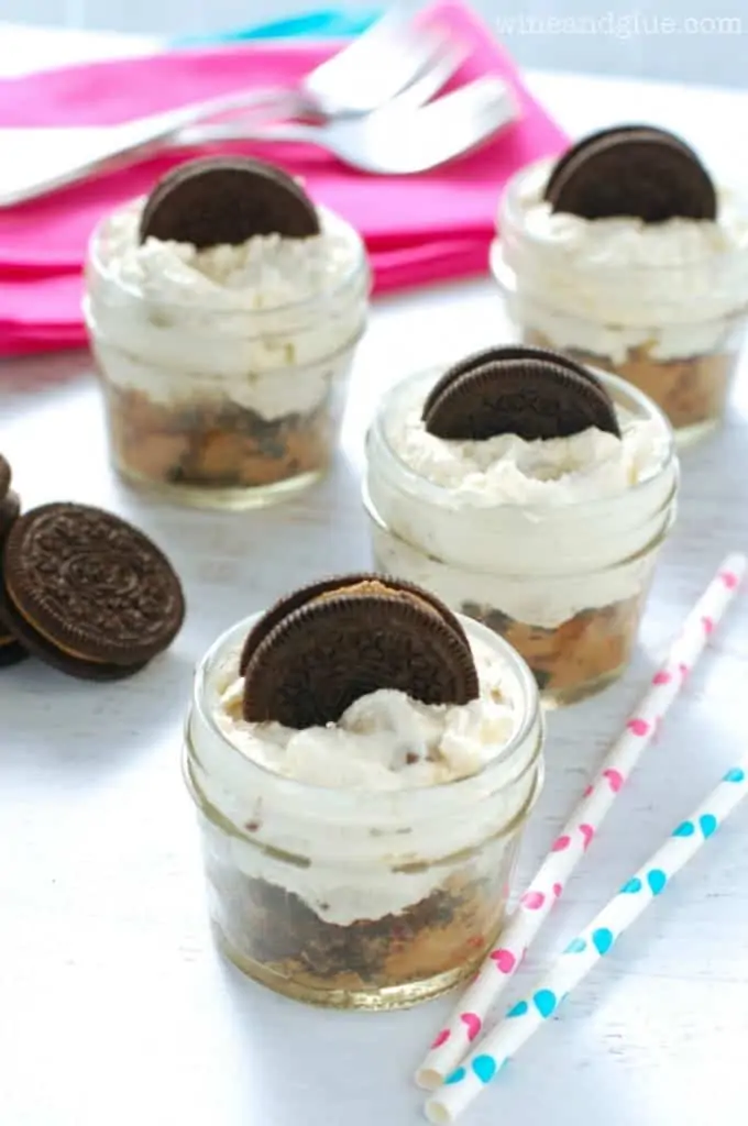 several small mason jars with cookie dough cheesecake in them