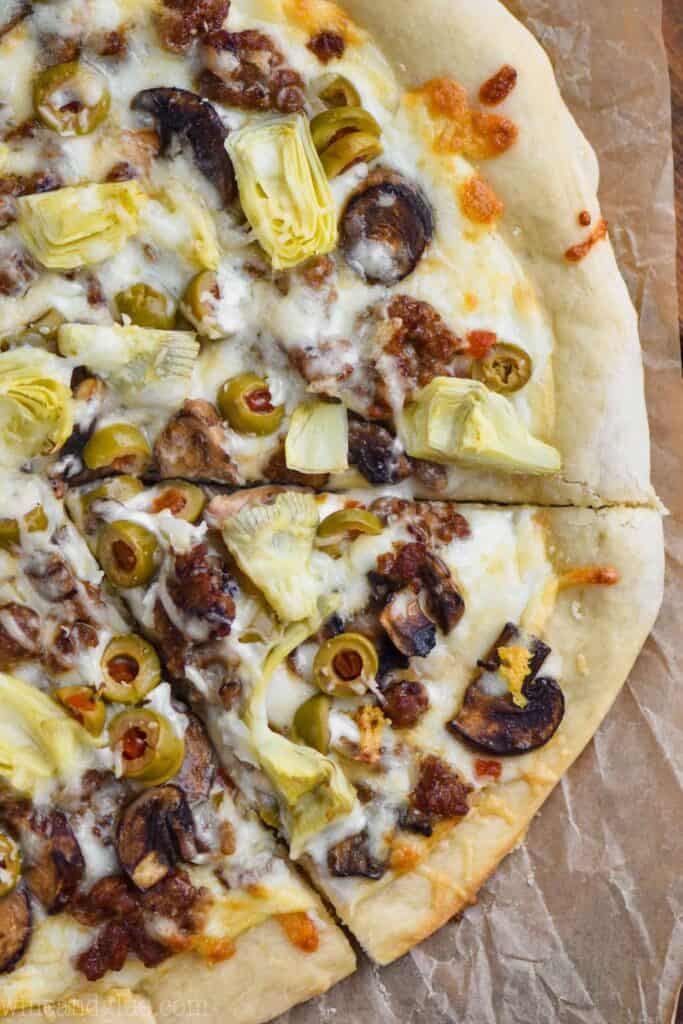 overhead view of half of a white pizza recipe with one piece cut out and still sitting there