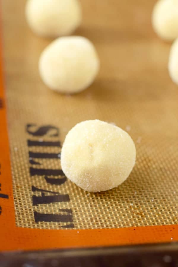 raw ball of sugar cookie dough sitting on a silpat reusable baking mat