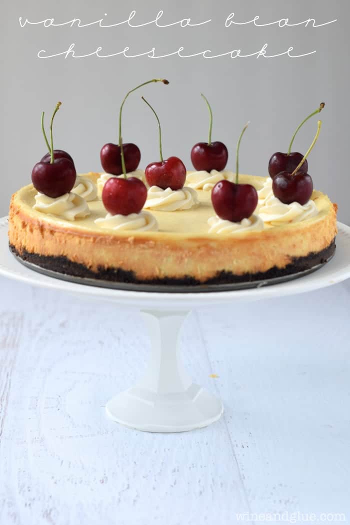 Vanilla Bean Cheesecake served on a platter with cherries on top. 