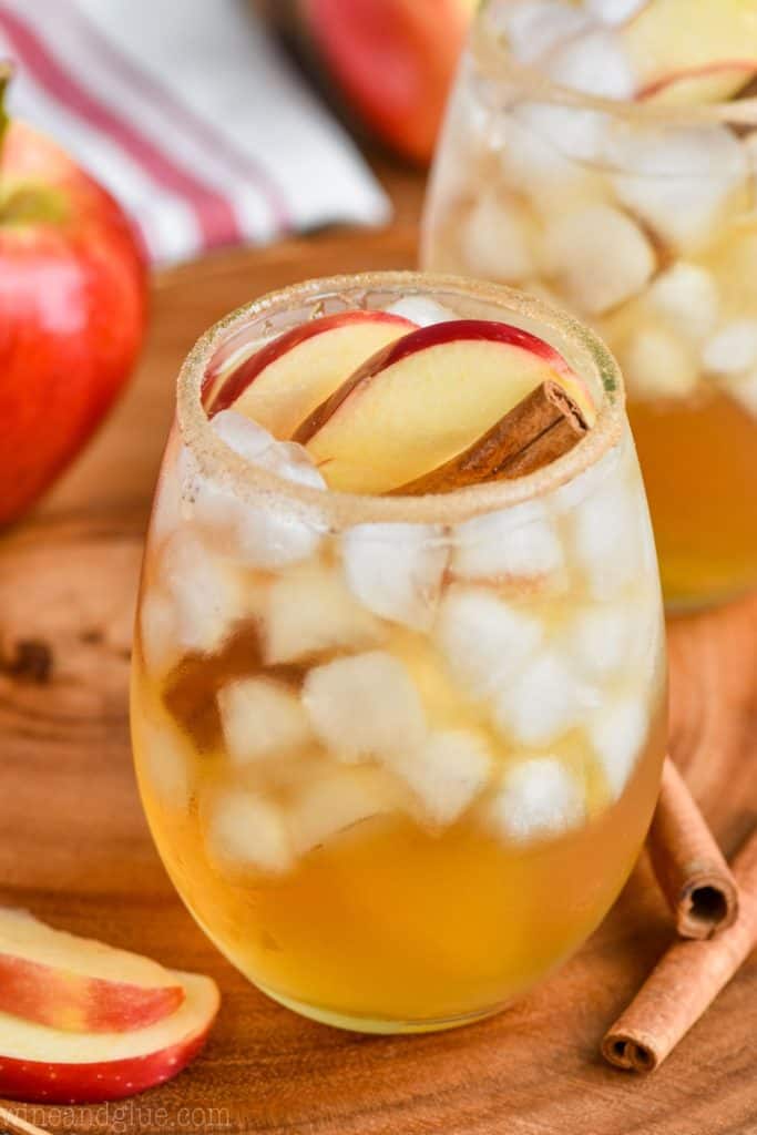 an apple cider margarita in a glass with ice and garnished with an apple