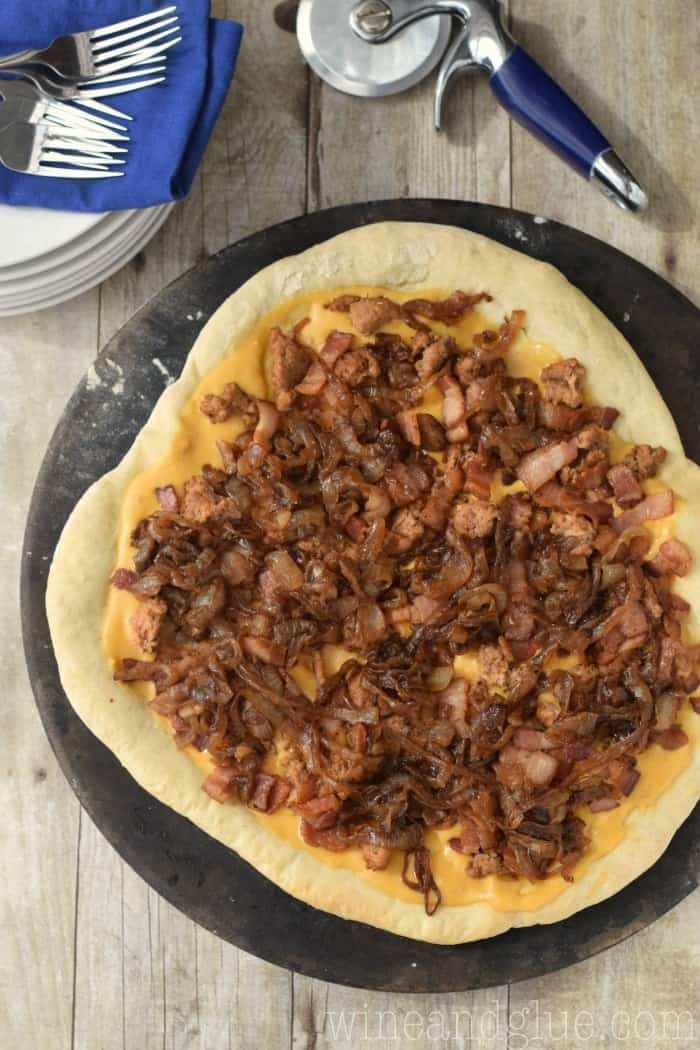 Beer Cheese Sauce Bacon Pizza with spicy sausage and caramelized onions