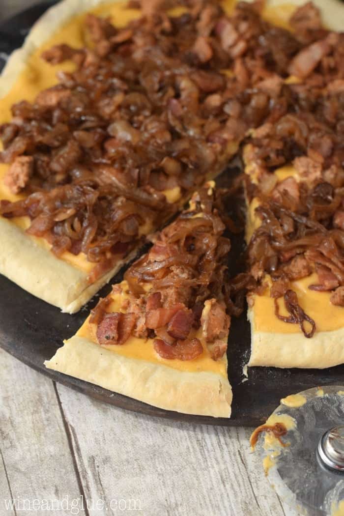 Delicious caramelized onions, spicy sausage, and bacon all over beer cheese sauce makes this serious pizza!