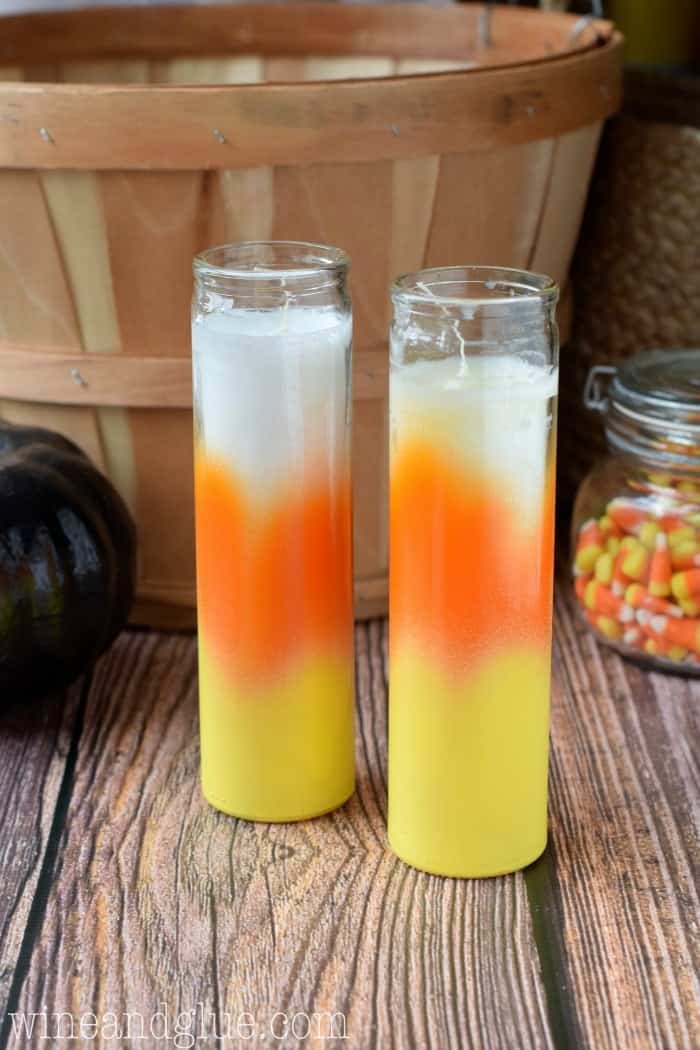 two prayer candles that have been spray painted to resemble candy corn