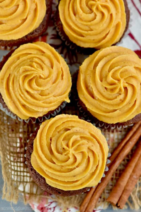 overhead look at five cupcakes that have pumpkin frosting piped in a rosette style on them