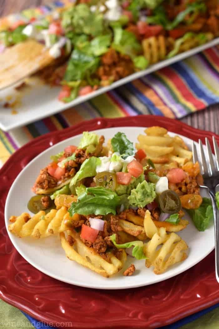 Delicious nachos made with lean meat, tons of veggies, and a homemade queso sauce, all over crispy waffle fries!