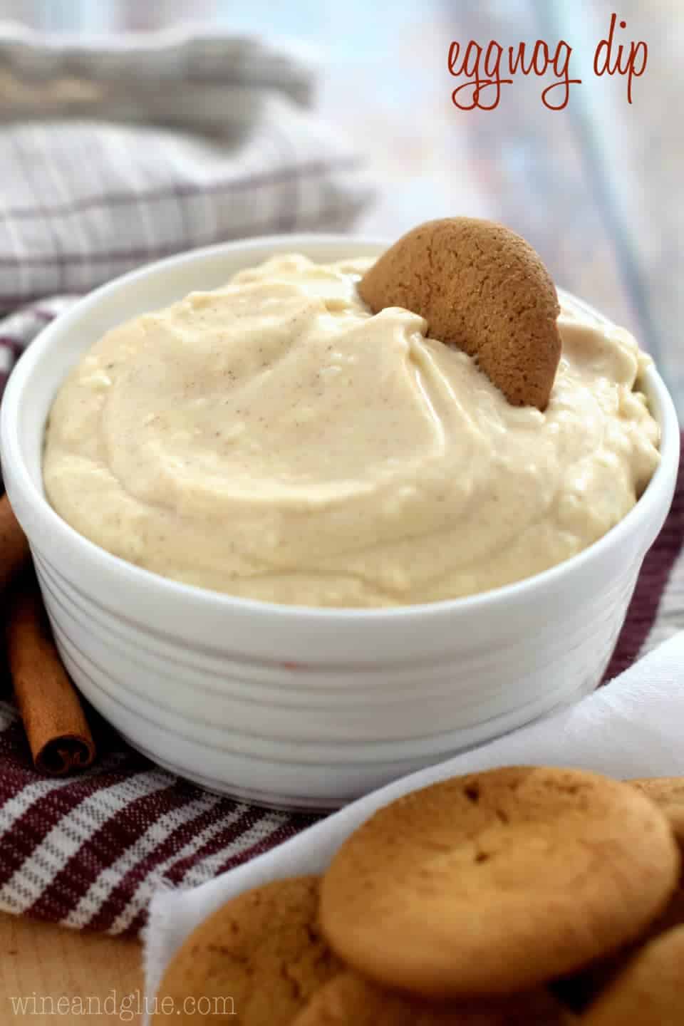 Small white bowl with eggnog dip, with a gingersnap, says: eggnog dip