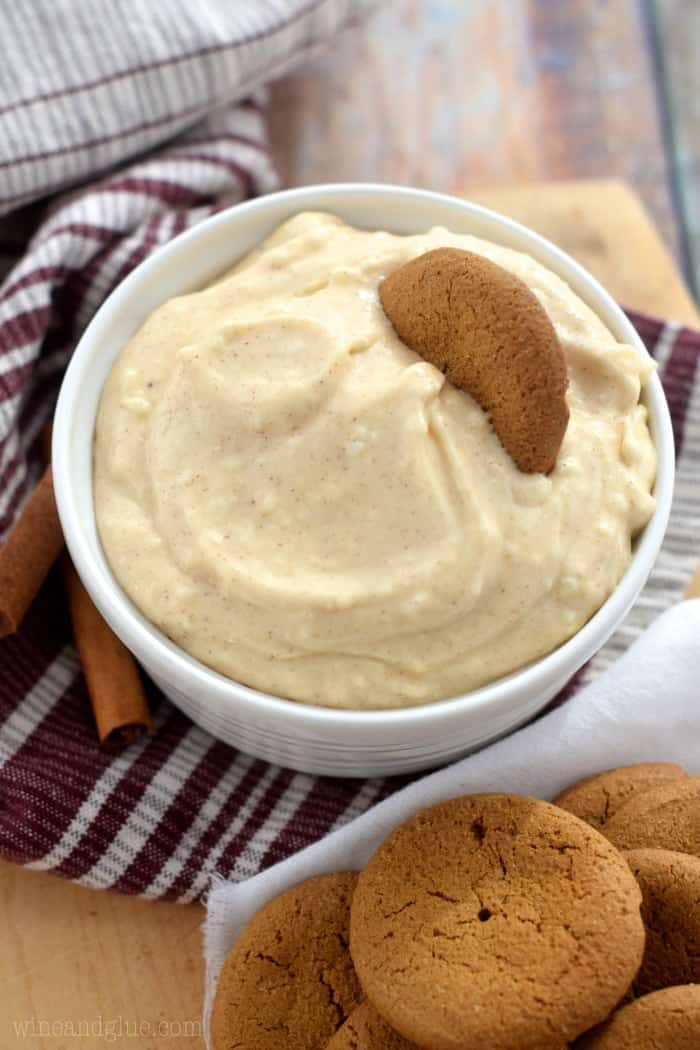 overhead of eggnog dip in a small white bowl with a gingersnap cookie in it