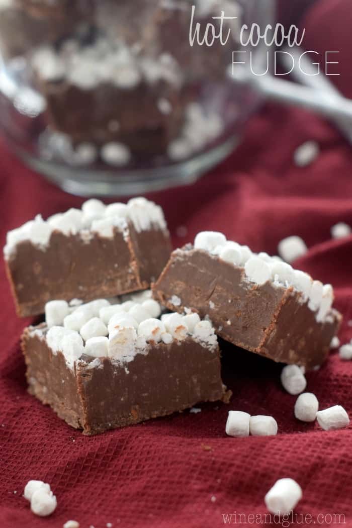 three small pieces of hot cocoa fudge with mini marshmallows on top