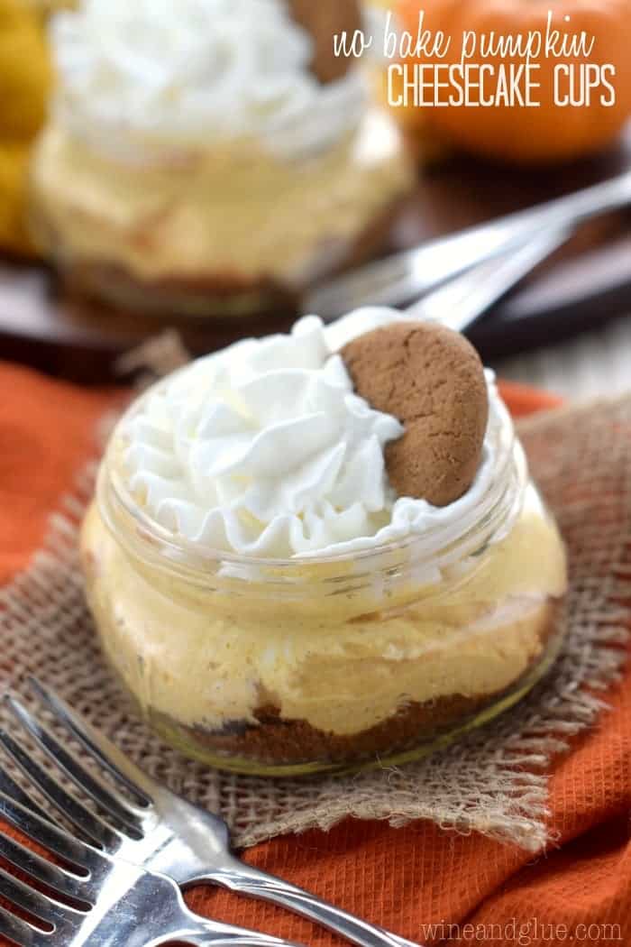 small mason jar filled with pumpkin cheesecake, topped with whipped cream, and a gingersnap cookie, says: no bake pumpkin cheesecake cups