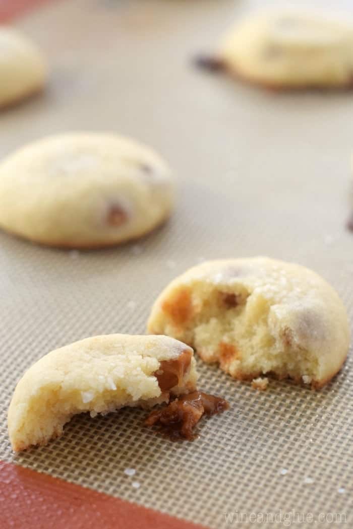 salted caramel sugar cookies on a baking mat that have been cut in half