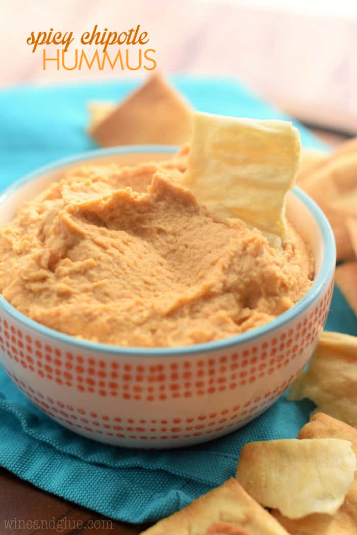 small bowl of chipotle hummus with a pita chip sticking out