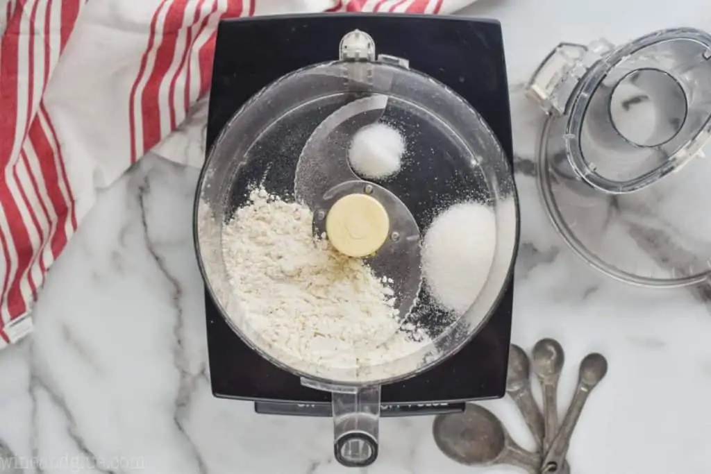 overhead view of a food processor with flour, sugar, and salt to create an easy pie crust