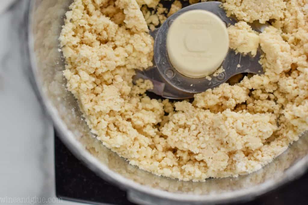 close up of the beginning of pie crust dough before the last bit of flour is added, mixture is crumbly, sizable chunks, and not pulled together