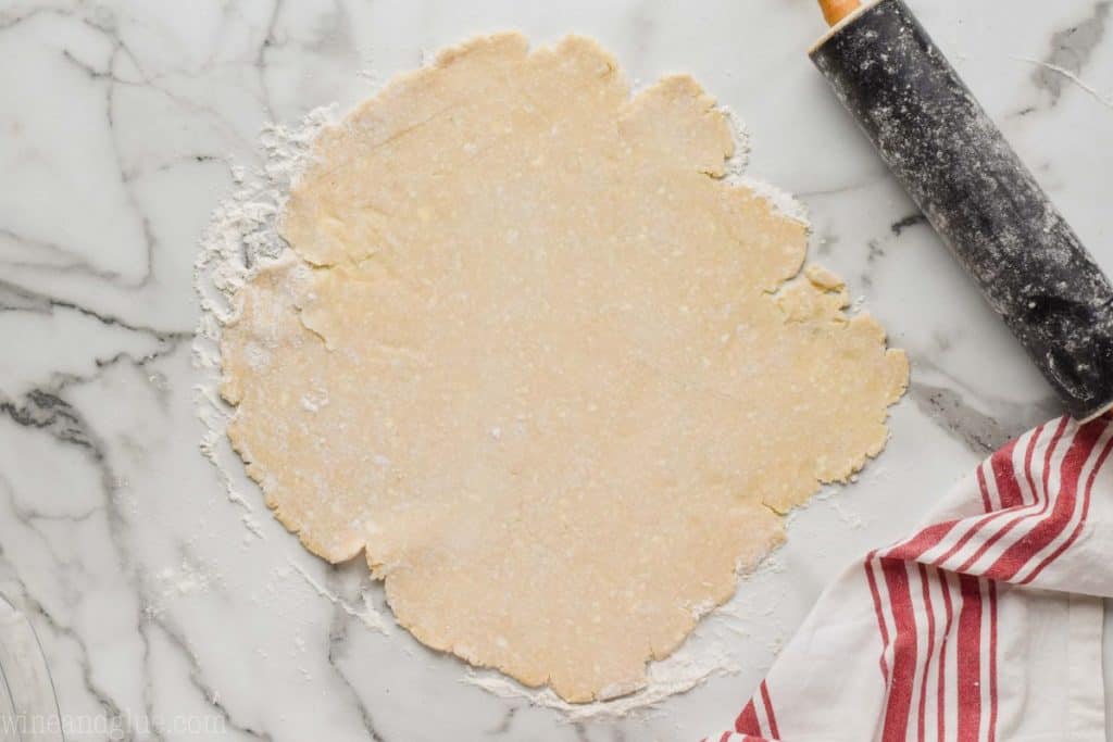 a flakey pie crust recipe that has been rolled out on a marble surface