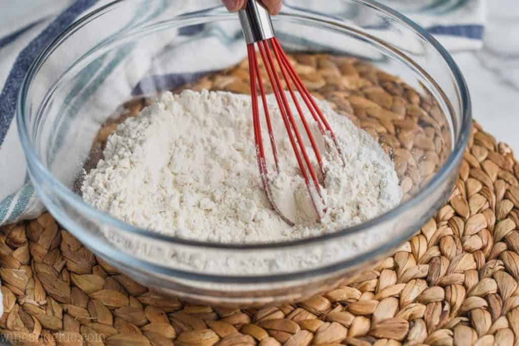 clear glass bowl with flour being whisked for easy biscuit recipe