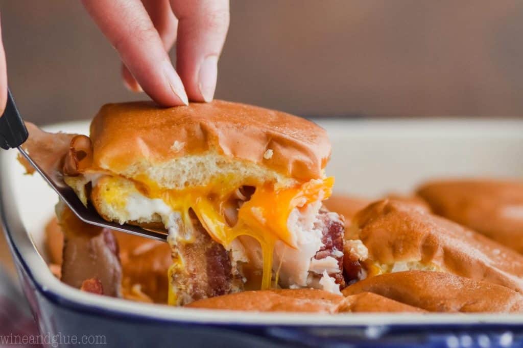 landscape style photo of a turkey slider coming out of the pan with cheddar cheese, bacon, and ranch dressing visible