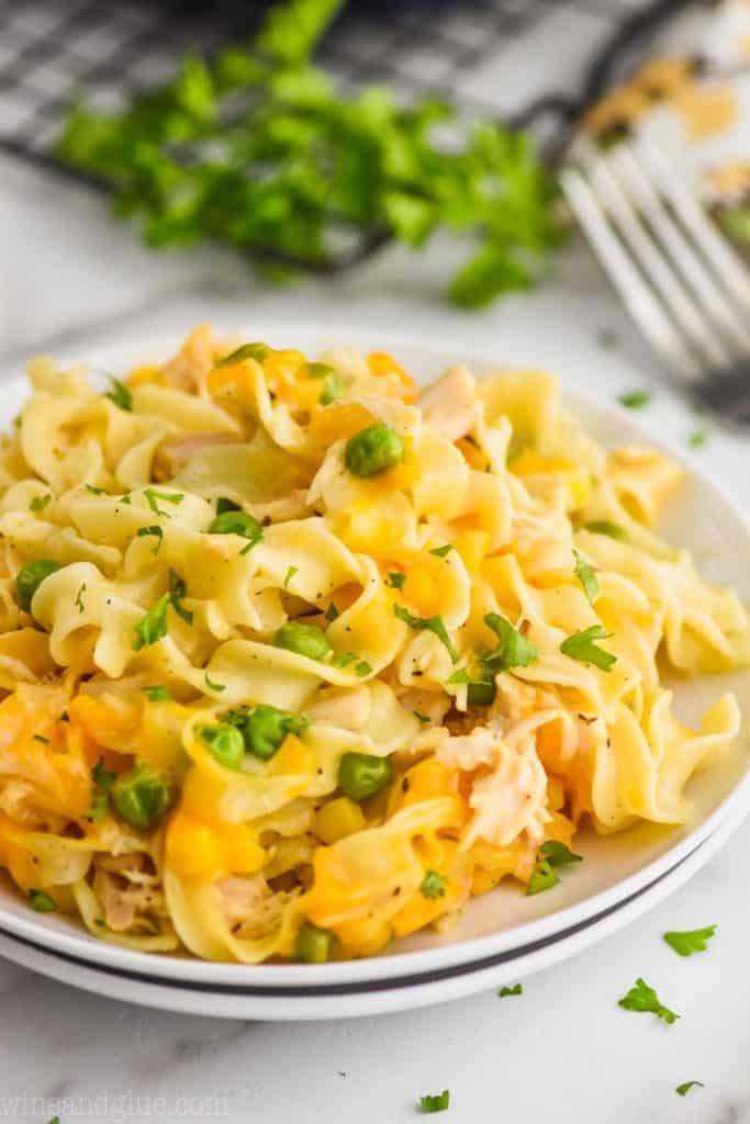 picture of two plates stacked full of turkey noodle casserole with parsley and a fork in the background