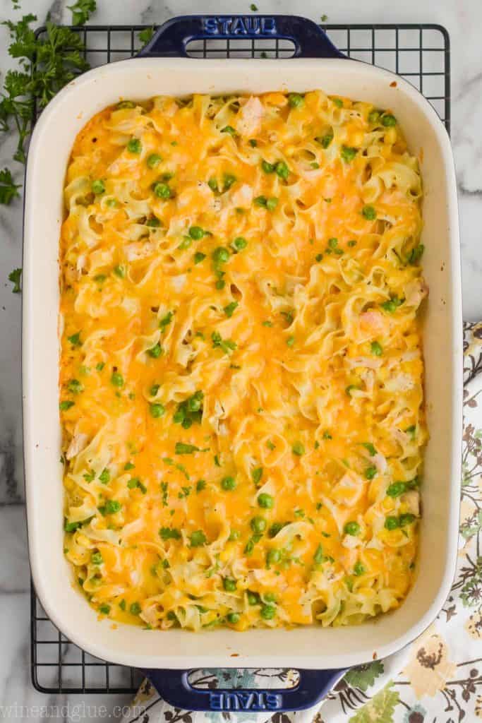 overhead view of a 9 x 13 inch ceramic baking dish full of cheesy turkey noodle casserole on a wire cooling rack