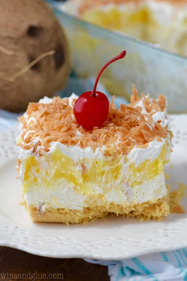 The No Bake Pina Colada Lush has a fluffy creamy inside with a pineapple layer and topped with toasted coconut flakes and a cherry. 