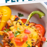 pinterest graphic of overhead of a stuffed taco pepper in a baking dish with cilantro and chopped tomatoes on top, says: the best taco stuffed peppers simplejoy.com