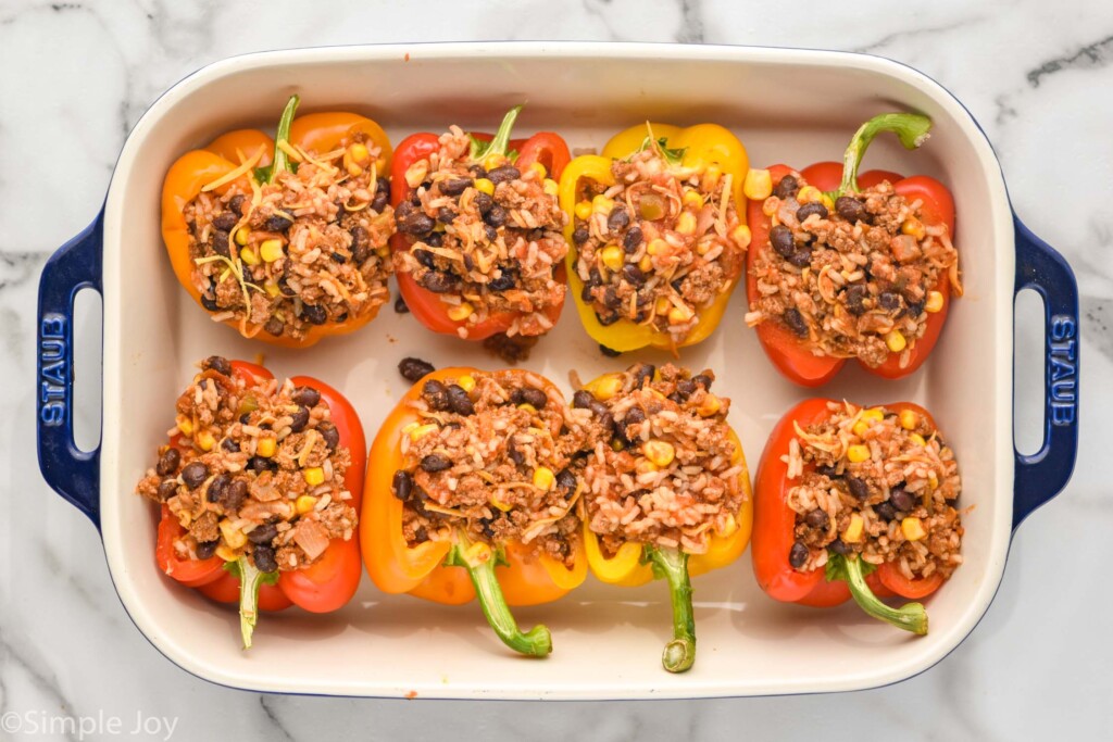 overhead of taco stuffed peppers in a baking dish before being cooked