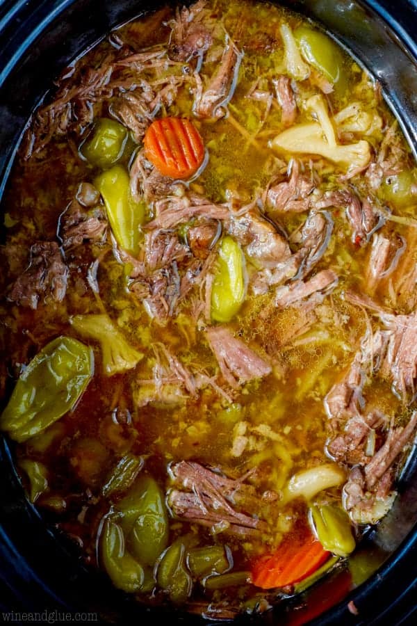 overhead view of crock pot italian beef in the slow cooker after being cooked