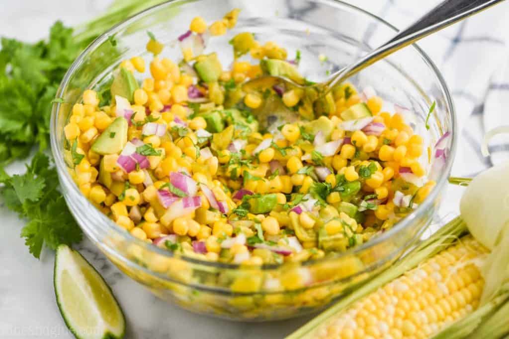 clear bowl full of avocado corn salsa