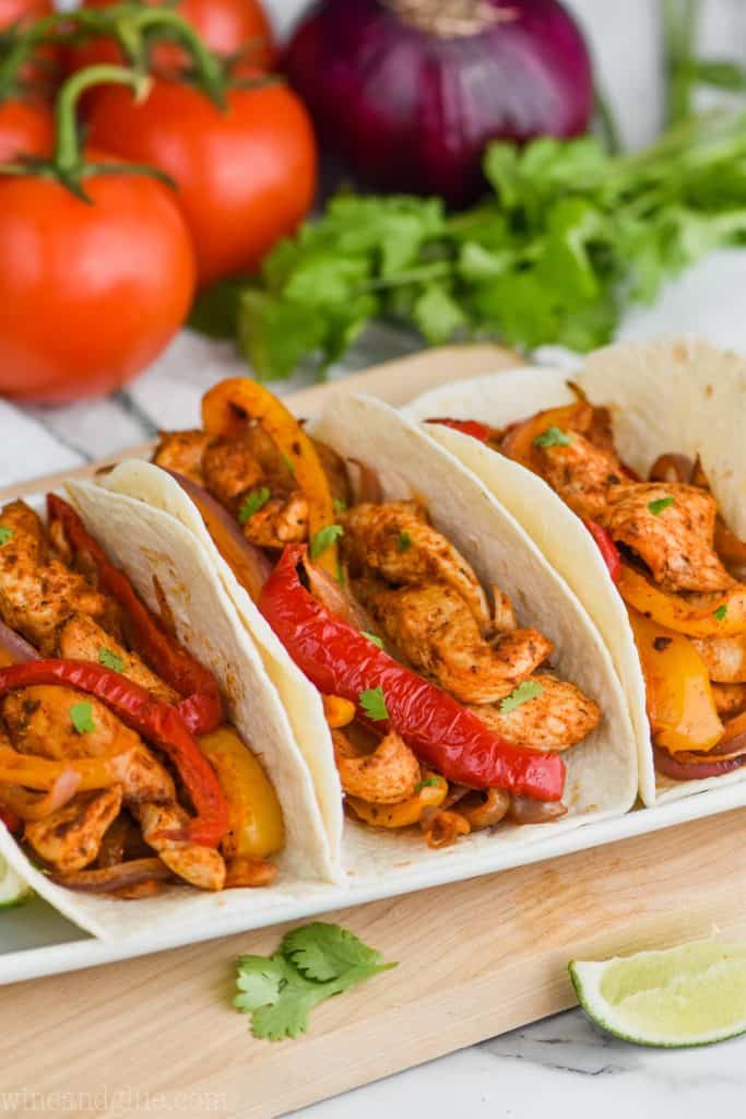 three chicken fajitas on a white plate