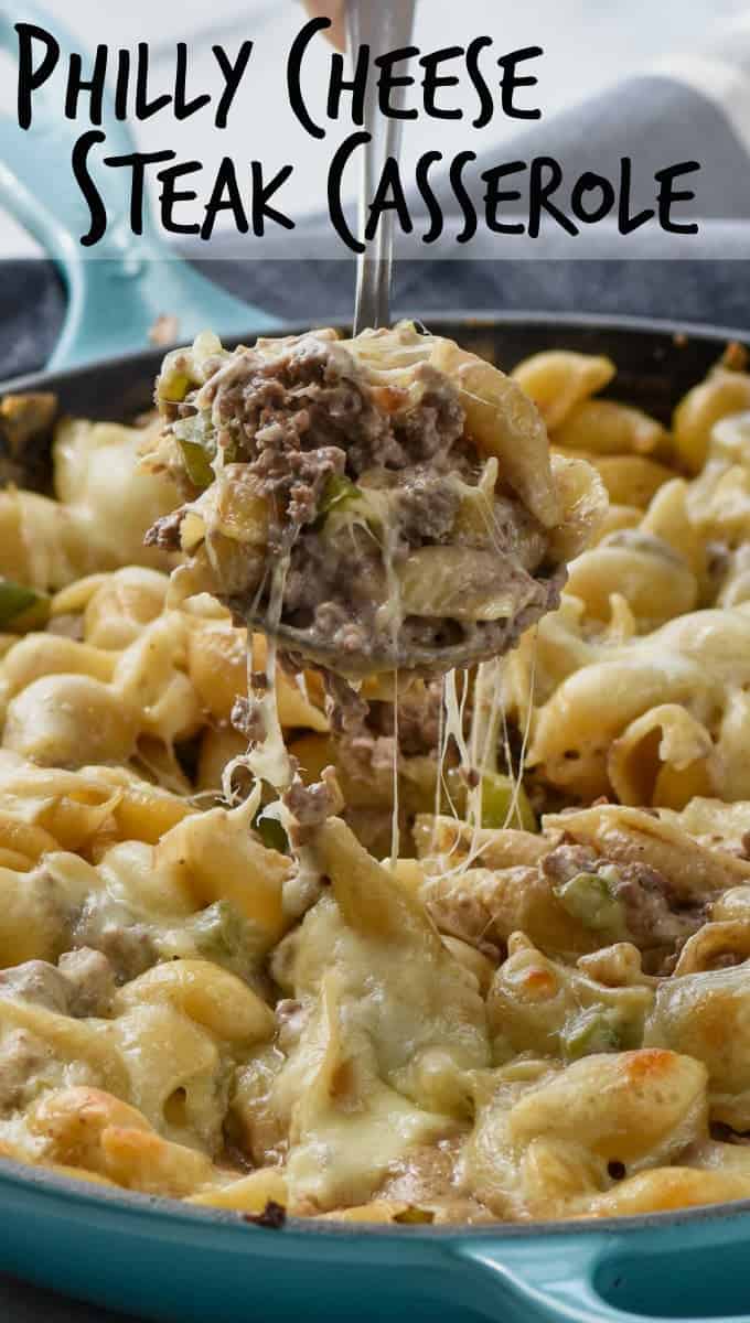 skillet full of phlily cheese steak casserole with spoonful being pulled out