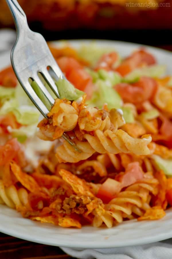 A close up of a fork digging into the Pasta Taco Casserole and some lettuce. 