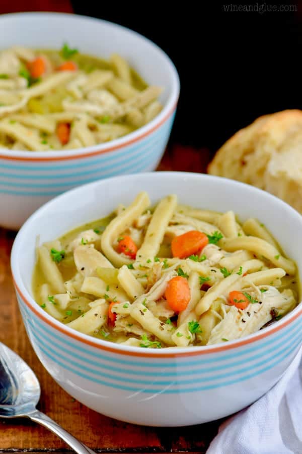 The Homemade Chicken Noodle Soup is in a small bowl and topped with ground black pepper and parsley.  