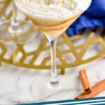 pinterest graphic of close view of an eggnog martini topped with whipped cream and cinnamon shavings, says: "eggnog martini simplejoy.com"