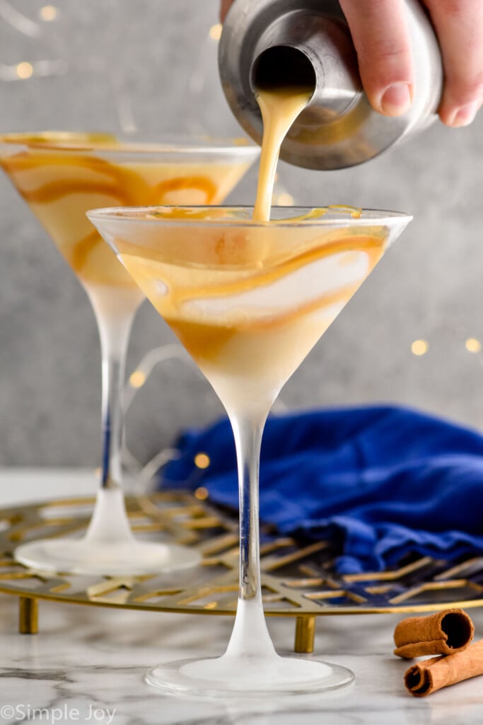 pouring an eggnog martini recipe into a caramel syrup lined martini glass