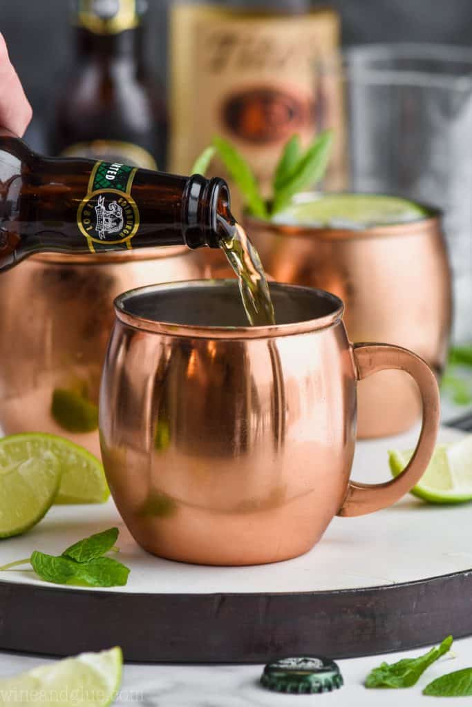 pouring the best ginger beer for a moscow mules into a copper mug