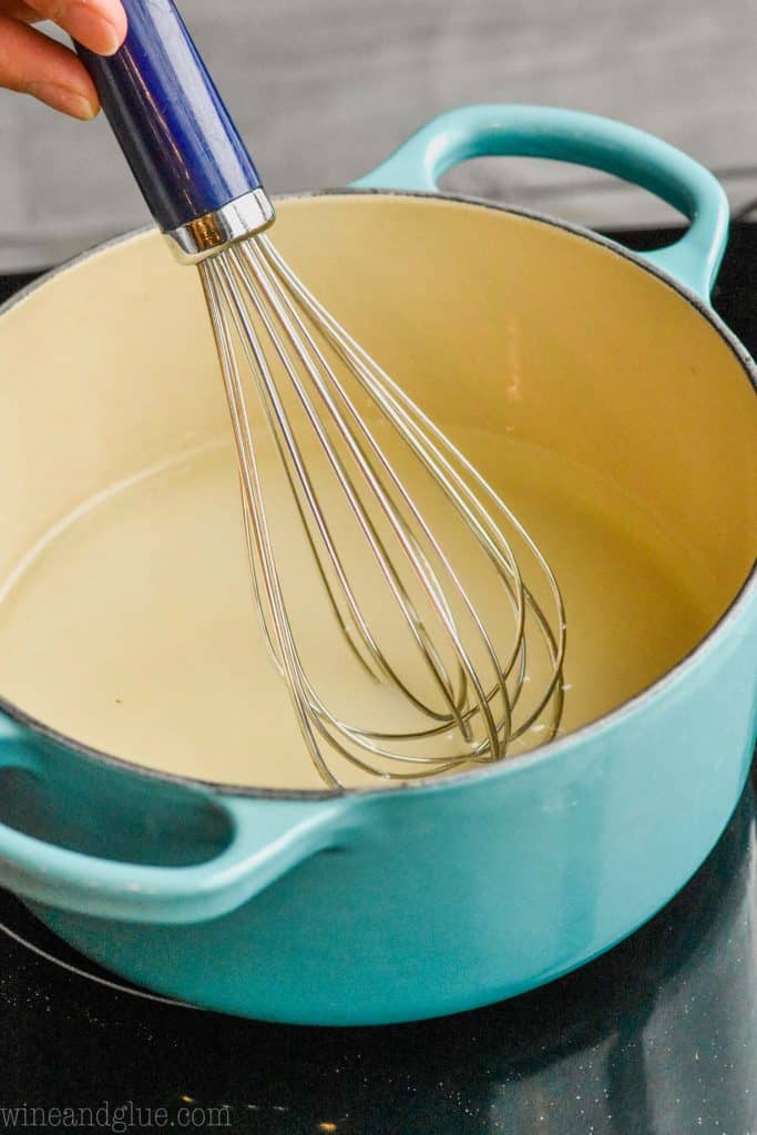 a whisk, whisking simple syrup to show how to make simple syrup