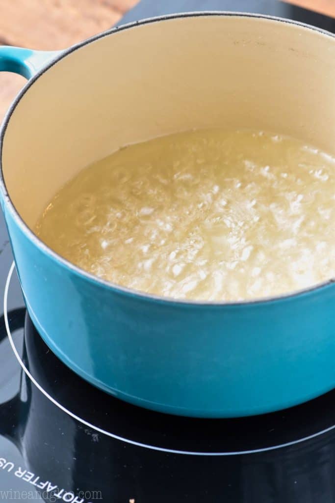 simple syrup bubbling as it cooks in a blue enamel sauce pan on top of a hot plate