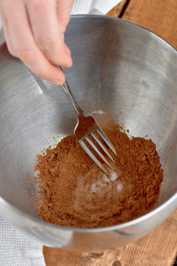 In a metal bowl, a fork mix the cocoa powder and sugar together. 