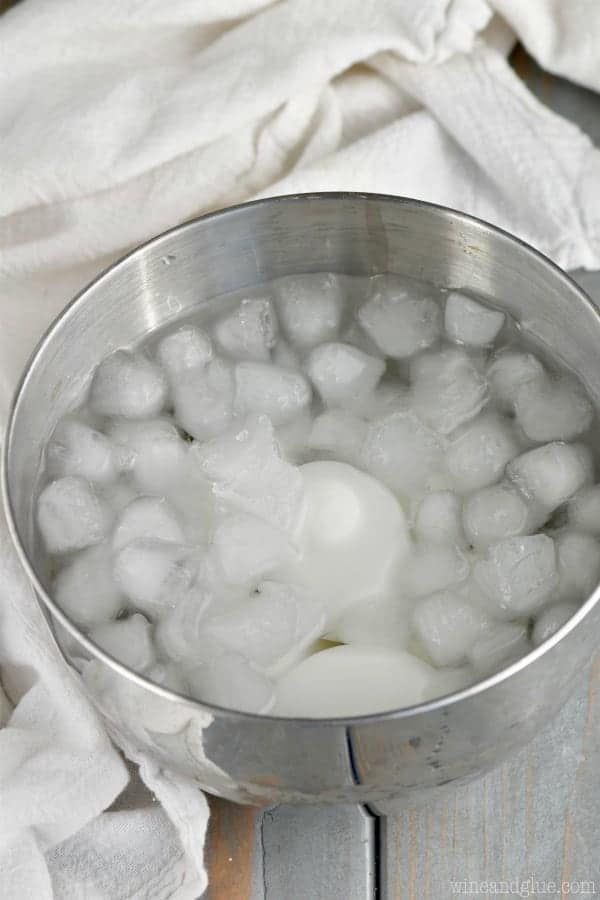 a metal bowl filled with ice water and hard boiled eggs