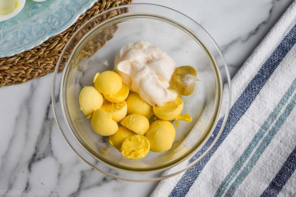 overhead view of a small bowl of egg yolks, mayonnaise, and seasoning for deviled eggs