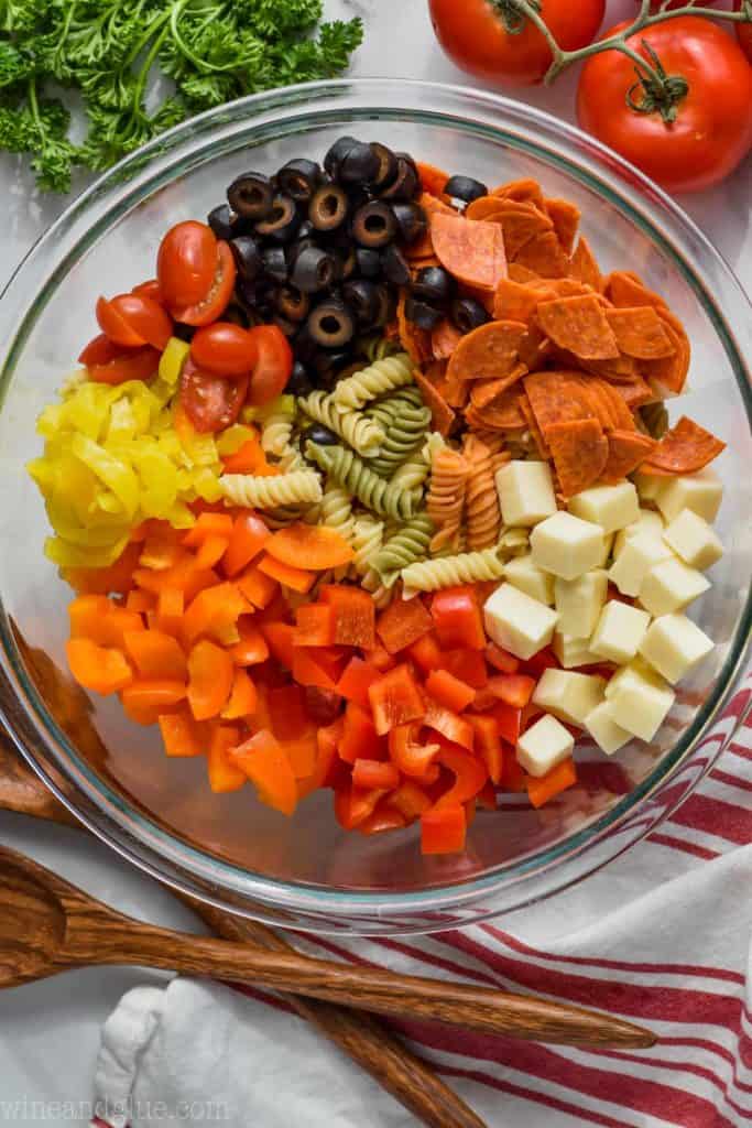 overhead photo of Italian pasta salad with peppers, cheese, pepperoni, olives, and tomatoes