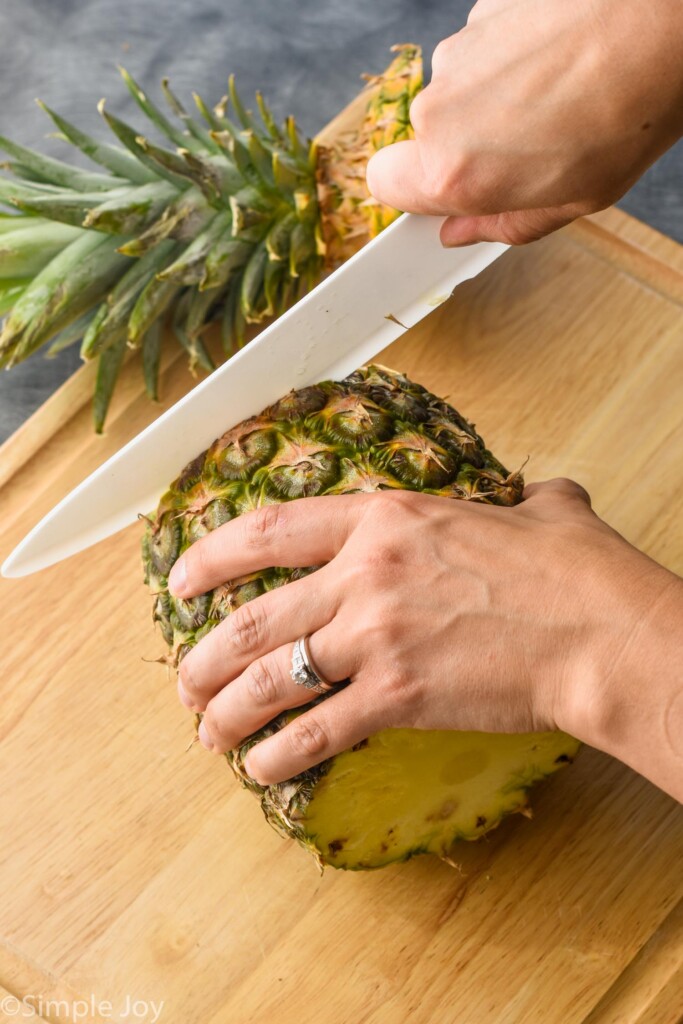 a pineapple on a cutting board with the bottom being cut off