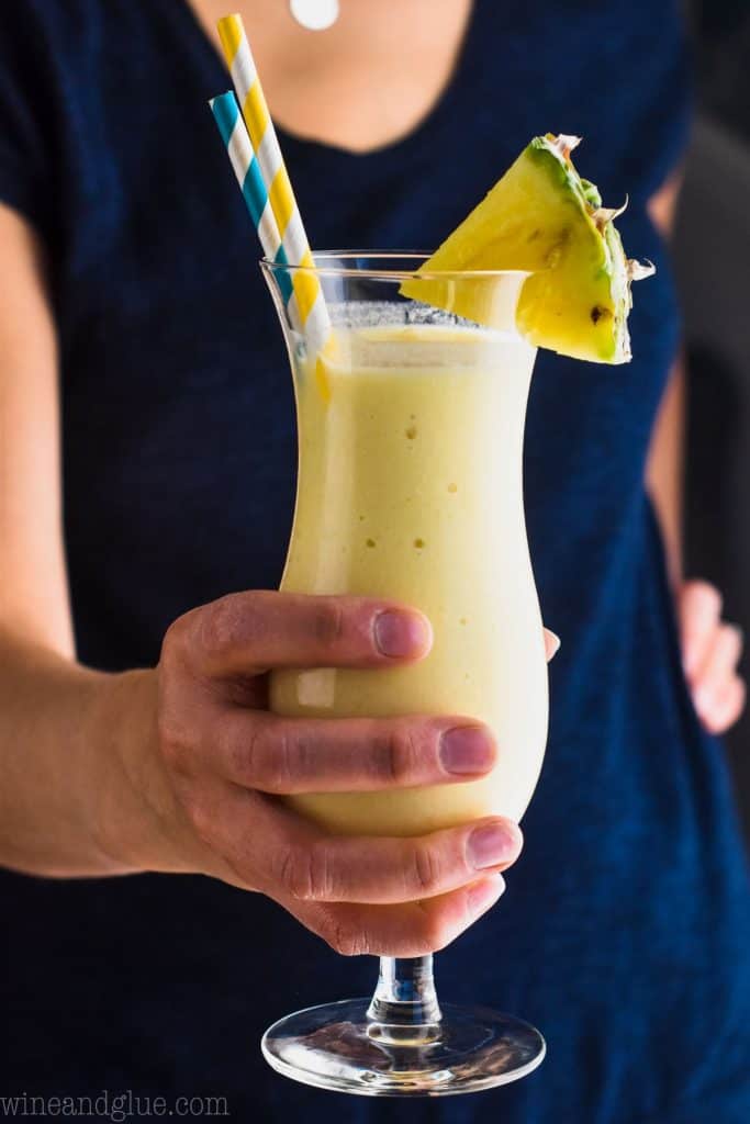 woman holding pina colada with coconut milk