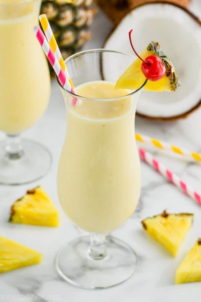 hurricane glass filled with an easy pina colada garnished with a pineapple